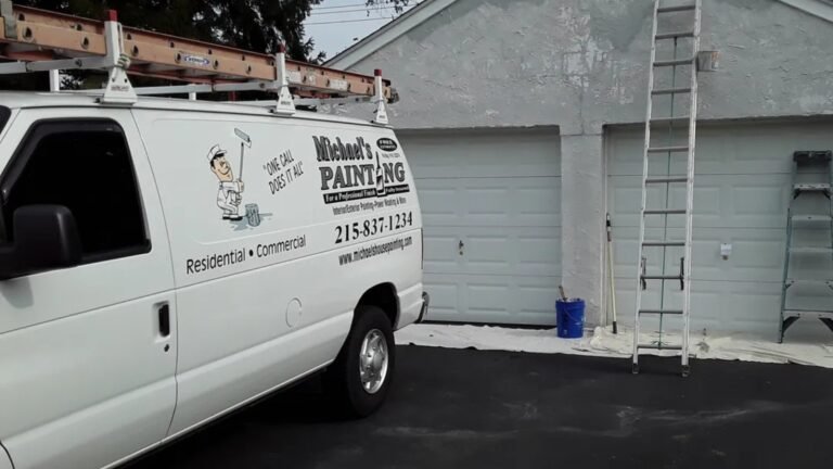 Exterior house painting in Philadelphia with ladders and preparation work on a two-car garage.