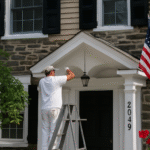 Professional painter applying fresh exterior paint on a house wall in Philadelphia