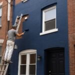 Painter working on a Philadelphia rowhome exterior.